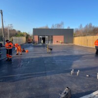 Commercial tarmacadam car park for CO-OP Tarmacadam crew working on car park construction for CO-OP store